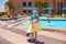 Cute kid, boy having fun in the pool, water sliding, summer activity