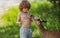 Cute kid feeding a baby fawn in the forest. Pretty boy with graceful animal at park. Kids adaptation.