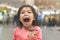 Cute kid girl eating sweet donuts and be dirty mouth on blur background with bokeh, selective focus