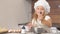Cute kid girl preparing dough for future baking cake with mother