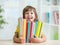Cute kid girl preschooler with books indoor