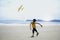 Cute kid having fun on sandy summer with blue sea, happy childhood boy playing model plane on tropical beach