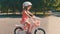Cute kid in safety helmet biking outdoors