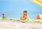 Cute kid in sunglasses resting on beach