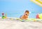 Cute kid in sunglasses resting on beach