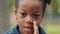 Cute kid telling secret quietly closing mouth with hand close up african american little girl looking at camera child