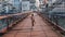 Cute kid walking the Saone River over the pedestrian Saint-Vincent Bridge alone