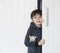 Cute kid wearing fluffy pajamas hugging dog toy playing hide and seek  in wardrobe, little boy looking out while holding the white