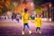 Cute kids, brothers holding hands, walking together on autumn street in yellow rain coats and boots