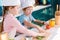 cute kids in chef hats and aprons preparing vegetable salad together