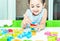 Cute kids female playing with toy designer on the floor at home. Child girl exciting while playing with alphabet colorful blocks.