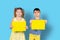 Cute kids posing with illuminating color blank for your advertisement. Photo on a blue background