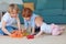 Cute kids, siblings playing toys together on the carpet at home