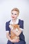 Cute kind woman with short hair in pinup polka dot dress holding her beloved pet on a white background in the Studio. plus size ad