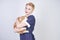 Cute kind woman with short hair in pinup polka dot dress holding her beloved pet on a white background in the Studio. plus size ad