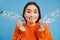 Cute korean woman shows two plastic bottles and smiles, recycles, sorts trash, collecting recycable items, blue