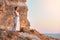 Cute lady in white dress posing on rock. Sunset over sea and nature. Contemplation and self absorbed idea, copy space