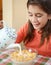 Cute latin girl eating breakfast at home