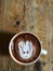 Cute Latte art coffee on the wooden table, latte art coffee shape look like `Groot`