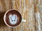 Cute Latte art coffee on the wooden table, latte art coffee shape look like `Groot`