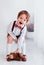 cute laughing toddler baby boy in festive outfit having fun with stuffed toy