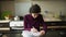 Cute left-handed girl learning to write with her right hand sitting at the table