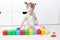 Cute little 2 years toddler girl playing with multicolored cubes