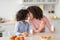 Cute Little Afro Girl And Woman Having Breakfast In Kitchen