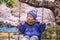 Cute little Asian 2 - 3 years old toddler boy child having fun swinging at children playground with sakura cherry blossom in Tokyo