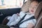 Cute little Asian 2 - 3 years toddler baby boy child sleeping in modern car seat. Child traveling safety on the road