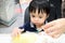 A cute little asian boy is picking food