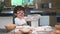 Cute little Asian boy sifting dough flour with sifter sieve colander in home kitchen for prepare to baking bakery and cake. Thai k