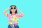 Cute little Asian kid girl wearing a flowers summer dress and sunglasses  on cyan background with copy space. Summer and