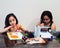 Cute little Asian siblings painting a picture in home studio