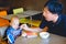 Cute little Asian toddler baby boy child doesn`t want to eat food, Dad feeding kid with spoon in high chair