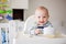 Cute little baby boy, eating mashed vegetables for lunch, mom fe