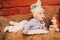 Cute little baby boy in funny bunny hat lying on straw