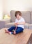 Cute little baby boy playing with colorful wooden pyramid at home. Kids skills development.