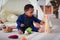 Cute little baby boy playing with wooden developing toy on the carpet at home