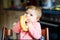 Cute little baby girl eating bread. Adorable child eating for the first time piece of pretzel or croissant. Healthy