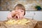 Cute little baby girl enjoying french fries on kitchen