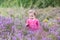 Cute little baby girl with purple heather flowers