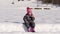 Cute little baby girl in snowsuit have snack taking break on snowshoeing hike in snow winter countryside