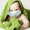 Cute little baby in medical protective face mask