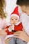 Cute little baby in Santa hat and costume on soft fabric like snow. Baby`s first Christmas