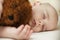 Cute little baby sleeping in a sweet sleep hugging a bear