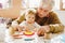 Cute little baby toddler girl and handsome senior grandfather painting with colorful pencils at home. Grandchild and man
