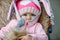 Cute little beautiful baby girl sitting in the pram or stroller on autumn day. Happy smiling child in warm clothes