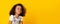 Cute little black girl sincerely laughing over yellow background, long panorama
