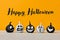 Cute Little Black and White Halloween Pumpkins with funny facial expressions standing side by side on white wooden table.